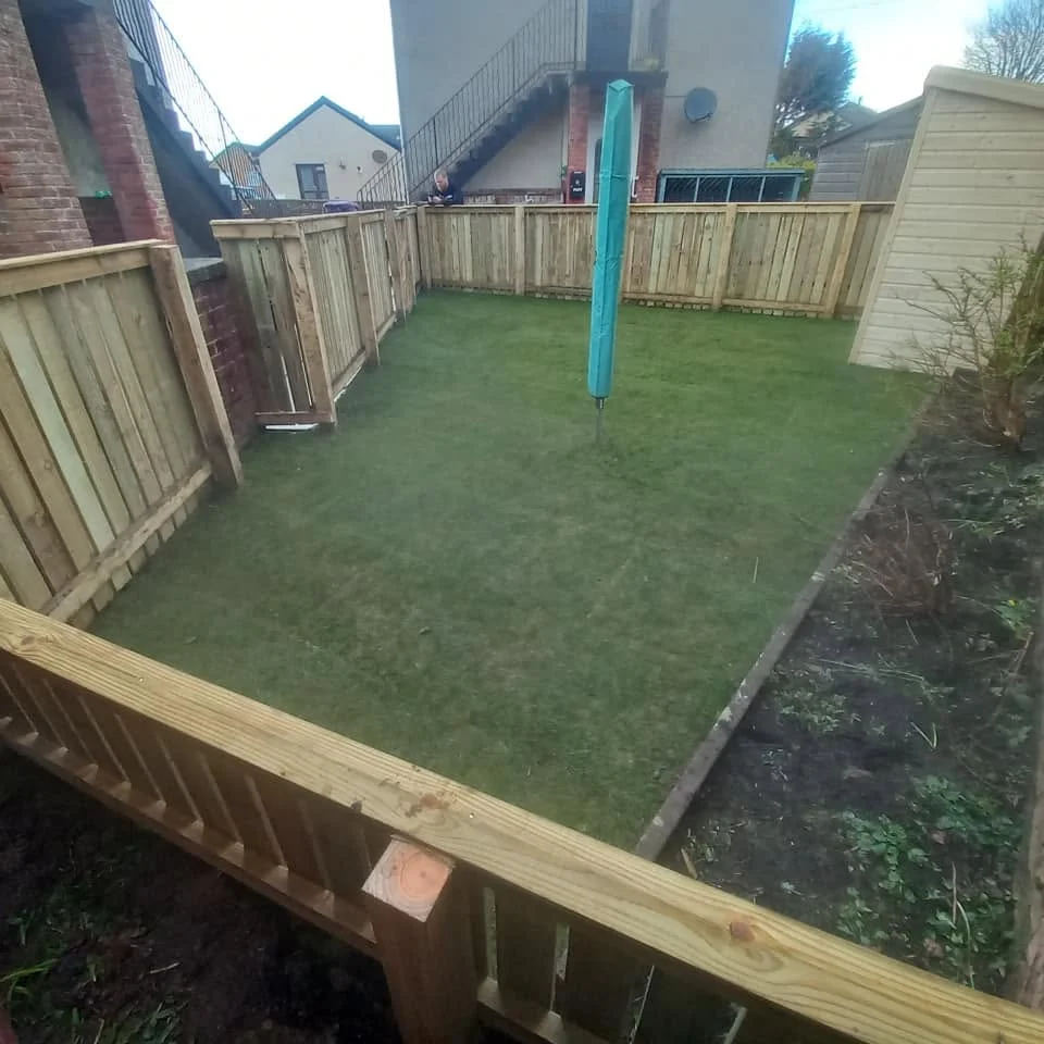 A neatly fenced garden with a lawn, completed by CM